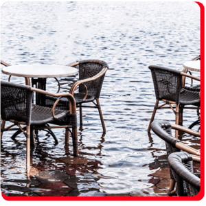 Flooded commercial patio area in Toronto after severe storm, showing standing water around furniture