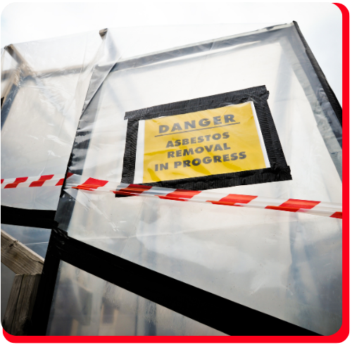 Plastic-sealed containment area with ‘Danger Asbestos Removal In Progress’ sign used during commercial asbestos removal in Toronto.