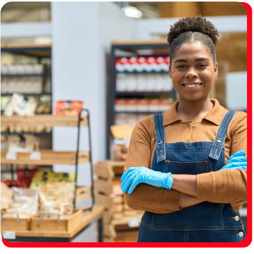 Smiling retail worker in a restored store environment, wearing protective gloves—representing catastrophe contents restoration services in Toronto for commercial businesses affected by fire, flood, or other disasters.