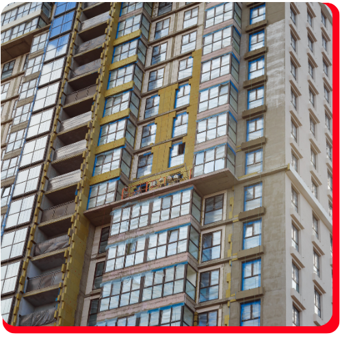High rise building undergoing exterior facade restoration with construction scaffolding and new window installations in progress — photographed in Toronto.
