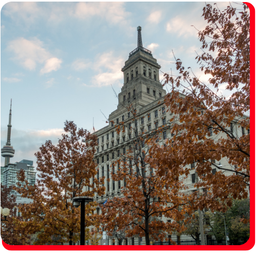 Dominion Public Building in Toronto, Ontario, Canada, with restored historic concrete facade, surrounded by autumn trees and city skyline, including the CN Tower in the background. Dominion Public Building in Toronto, Ontario, Canada, with restored historic concrete facade, surrounded by autumn trees and city skyline, including the CN Tower in the background.