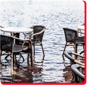 Flooded commercial patio area in Toronto after severe storm, showing standing water around furniture