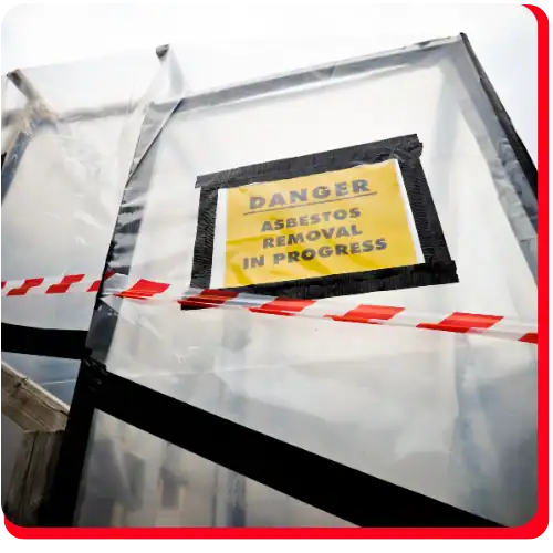 A plastic barrier with a “Danger Asbestos Removal In Progress” sign and red warning tape blocks off a hazardous area during commercial restoration, fire damage restoration, water damage restoration, commercial fire restoration, or commercial water damage restoration activities.