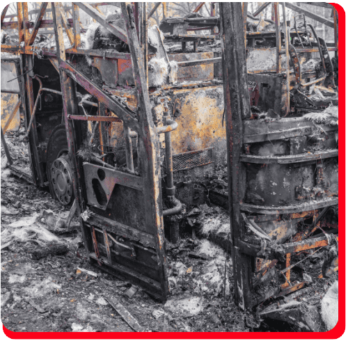 Charred remains of a commercial vehicle after a severe fire, showing extensive structural damage and soot—ideal for showcasing commercial fire cleanup and restoration services.
