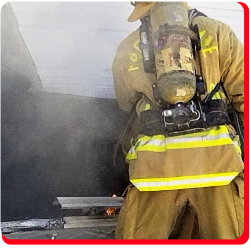 Firefighter in full protective gear responding to a smoke-filled commercial building in Toronto, indicating the need for emergency asbestos removal and hazardous material cleanup following fire-related structural damage.