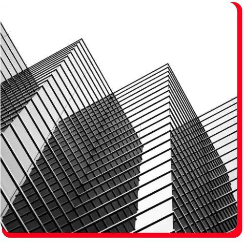 Black and white photo of modern glass buildings taken from a low angle, emphasizing geometric lines and reflective surfaces, symbolizing the strength and precision essential in commercial restoration. A thick red border on the top and right sides suggests urgency and reliability associated with commercial fire restoration, water damage restoration, and overall commercial water damage recovery.
