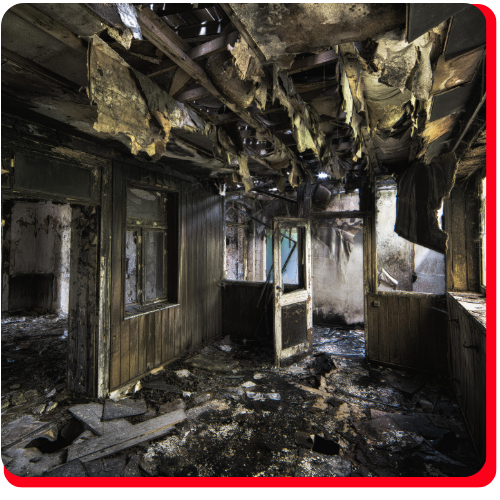 Severely burned commercial interior with collapsed ceiling and heavy soot damage, representing the aftermath of a fire requiring professional commercial fire cleanup services.